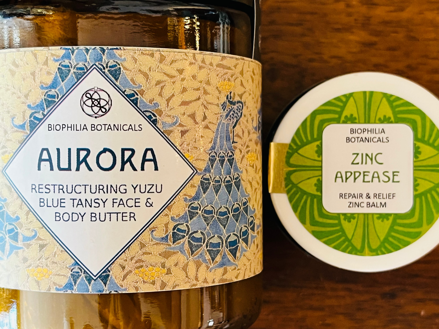 Bottle of Aurora body butter with decorative label on a wooden surface